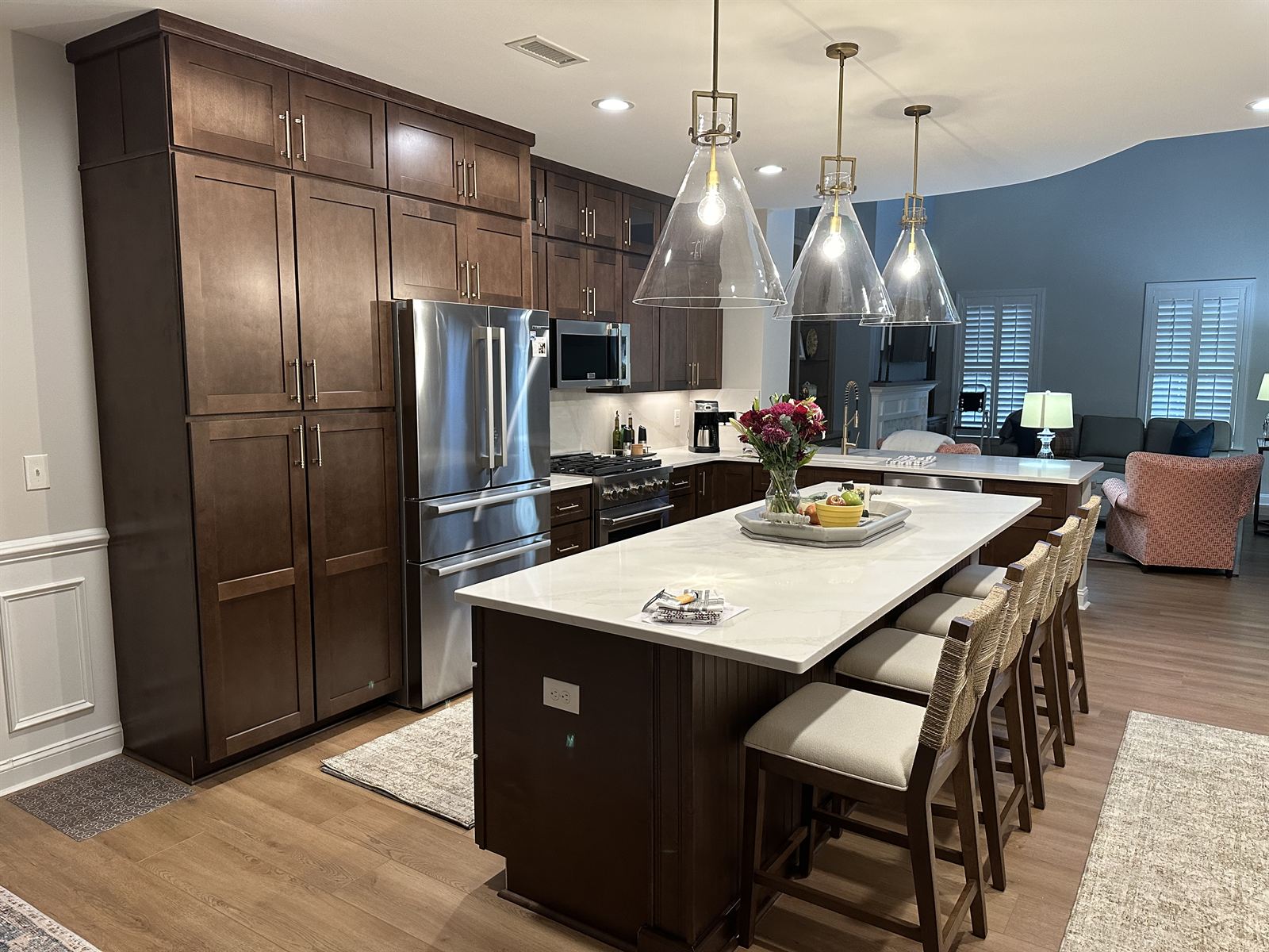 Kitchen remodel with dark stained shaker cabinets, white quartz island and glass pendant lighting