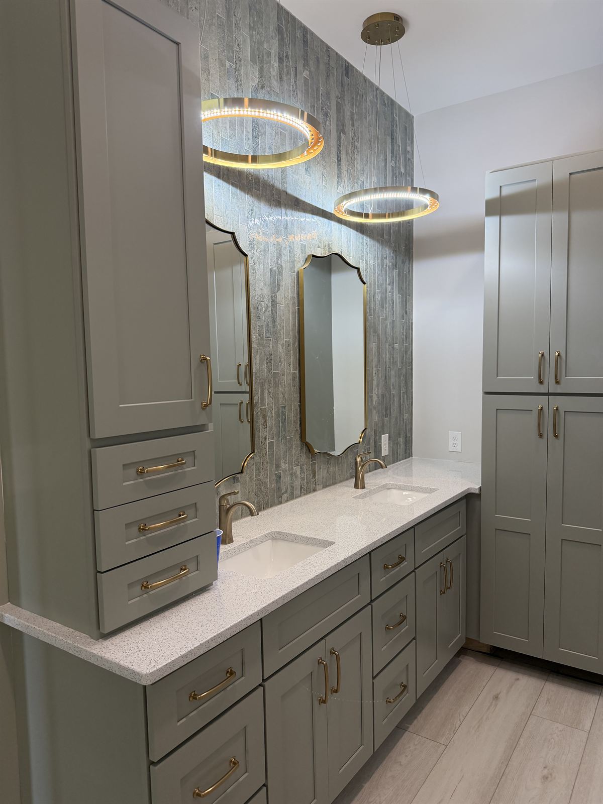 Bathroom remodel with double vanity, brass hardware, ring pendant lights and framed mirrors