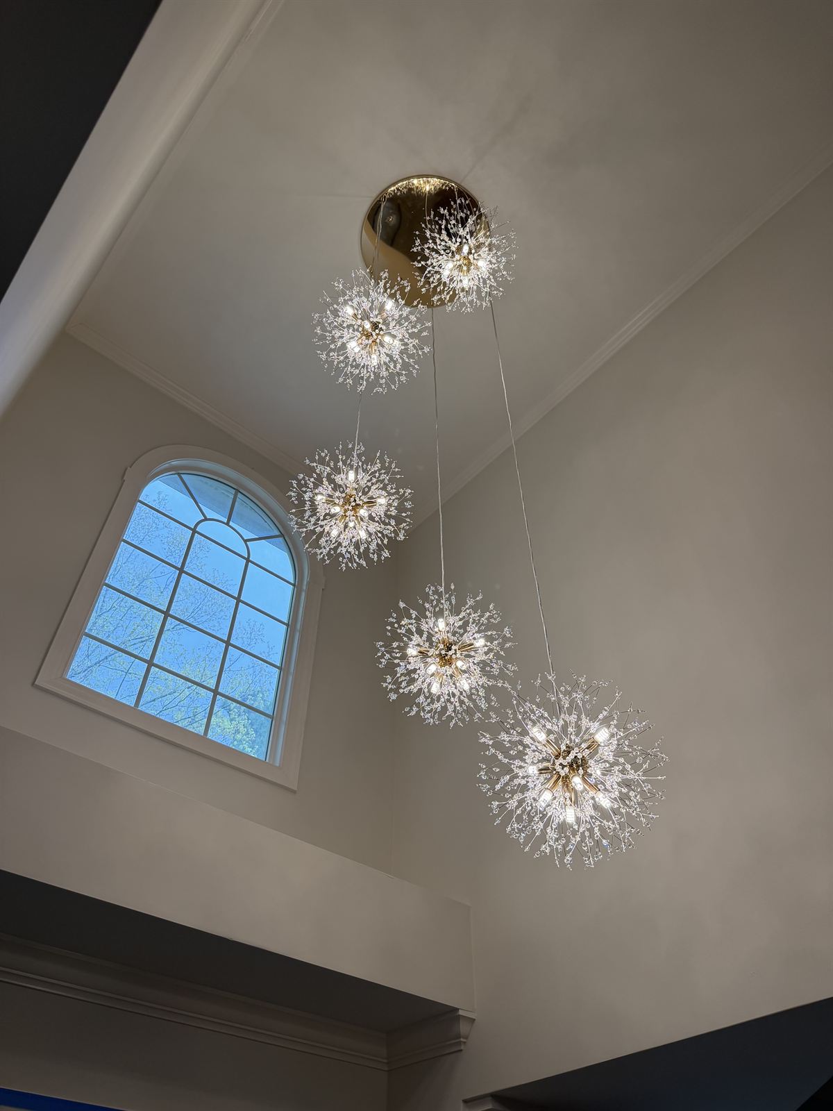 Crystal dandelion pendant chandelier cluster installed in a two-story foyer