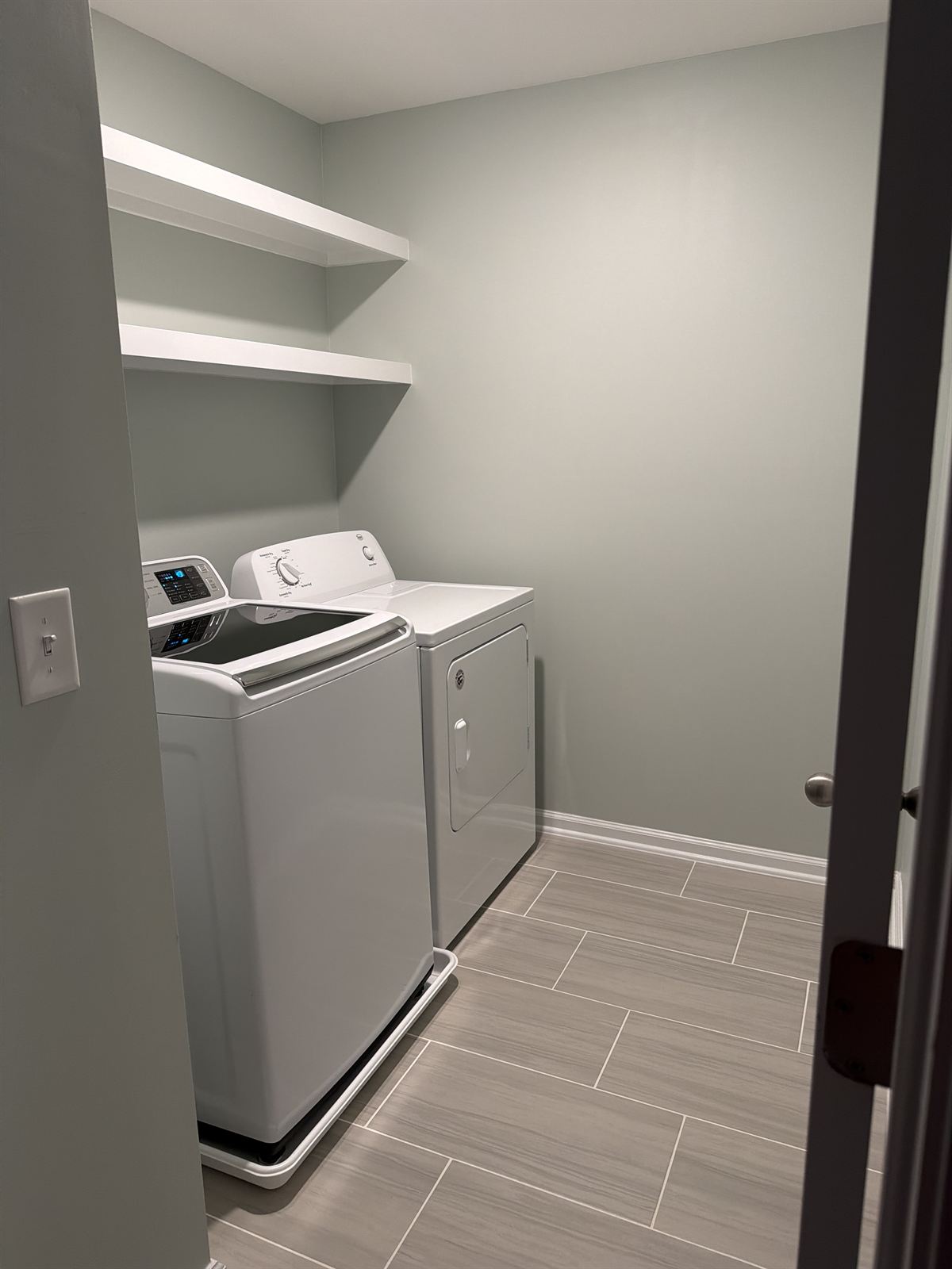 Laundry room remodel with new tile flooring and custom floating shelves