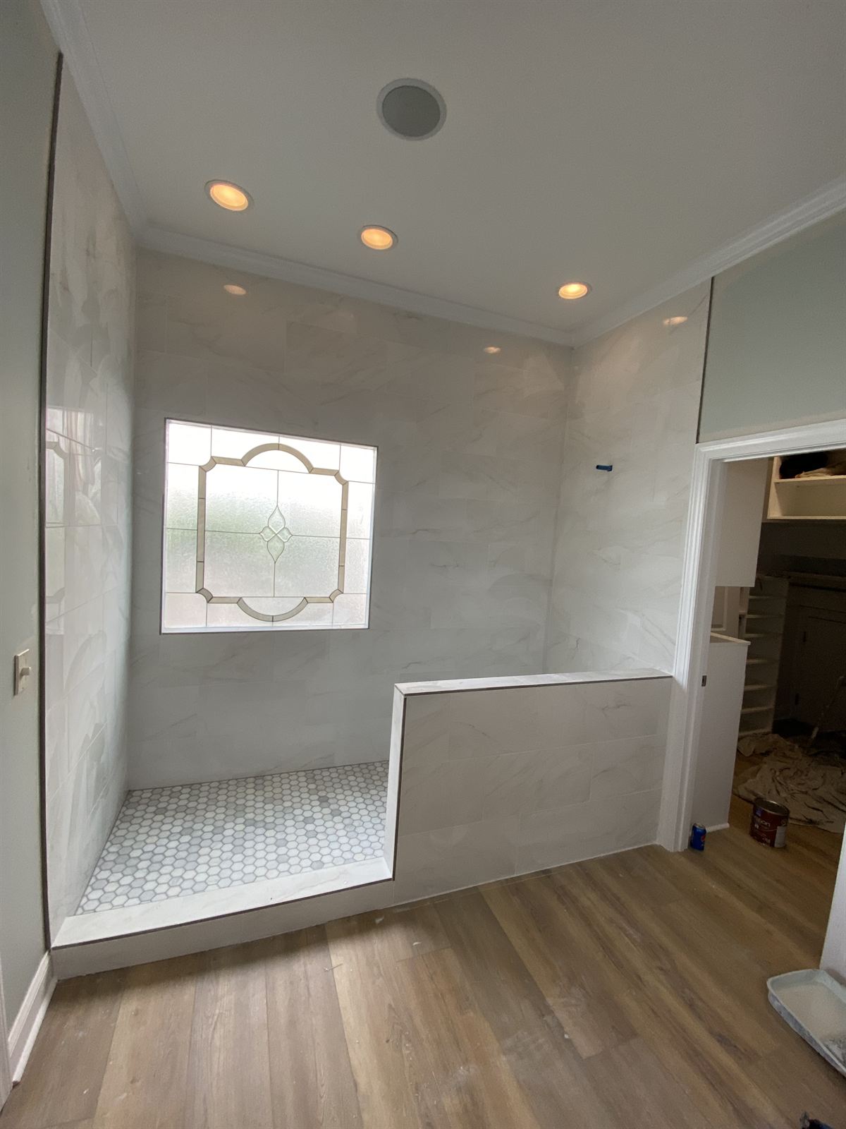Master bathroom remodel with marble-look tile walk-in shower, hexagon mosaic shower floor and luxury vinyl plank flooring