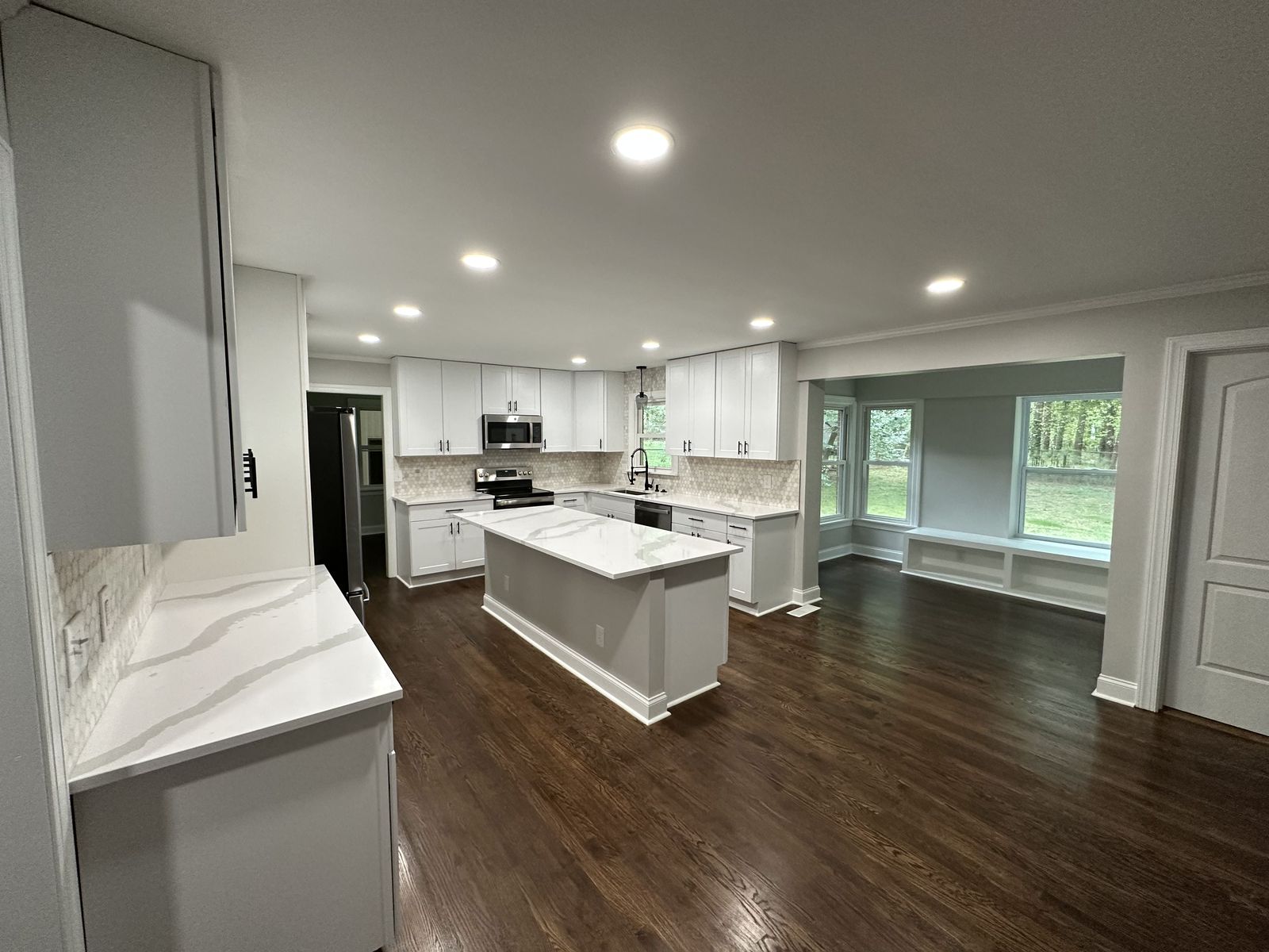 White kitchen with double wall ovens, open shelving and tile backsplash